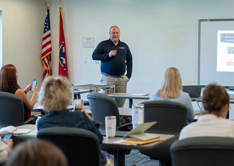 Randy Murray of LEIC gives a presentation to colleagues in a large classroom.